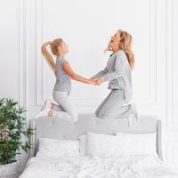 Mother and daughter jumping on the bed